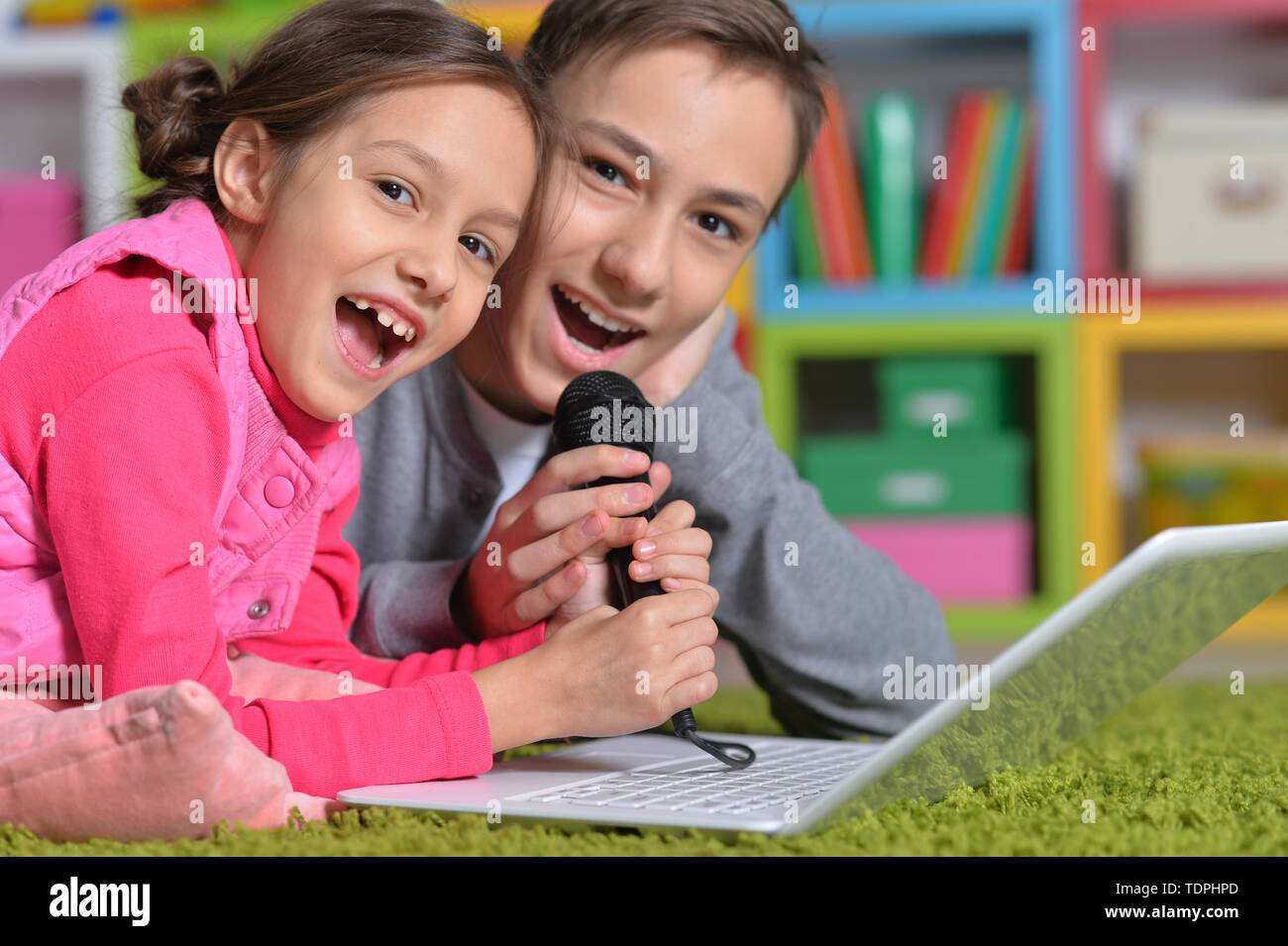 Adorable little girl and boy singing karaoke Stock Photo Alamy