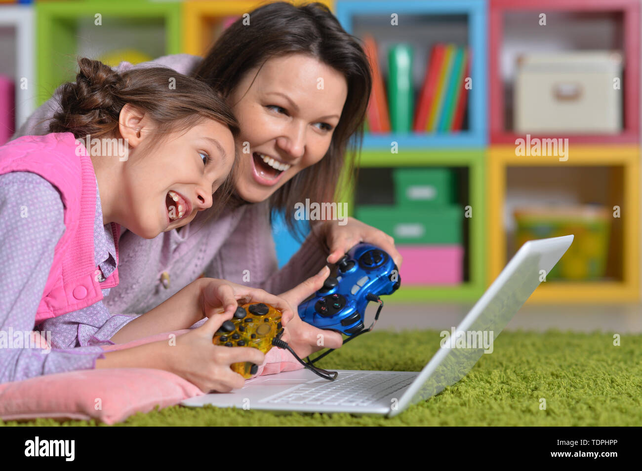 Mother and daughter playing computer game with laptop Stock Photo - Alamy