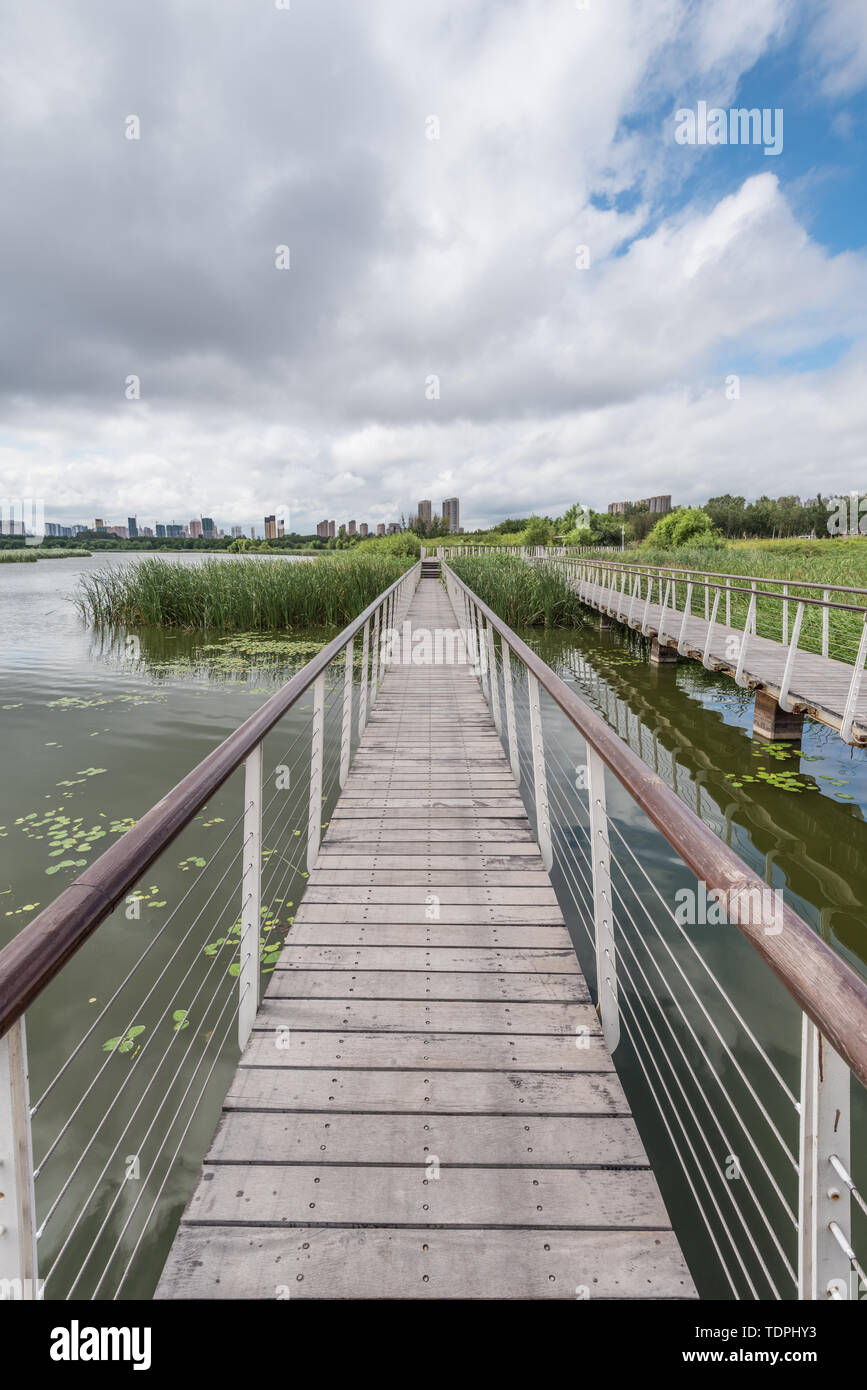 Lakeside construction green space trestle under cloudy weather Stock