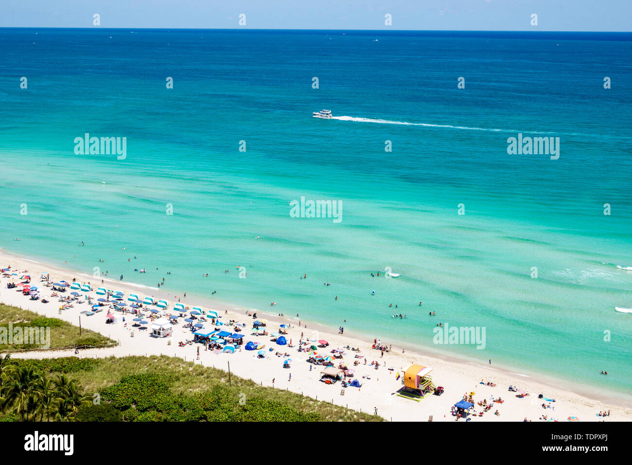 Miami Beach Florida,North Beach,Atlantic Ocean,sunbathers,public beach,sand,umbrellas,horizon,overhead view,clear blue water,sand bank,dunes,boat,FL19 Stock Photo