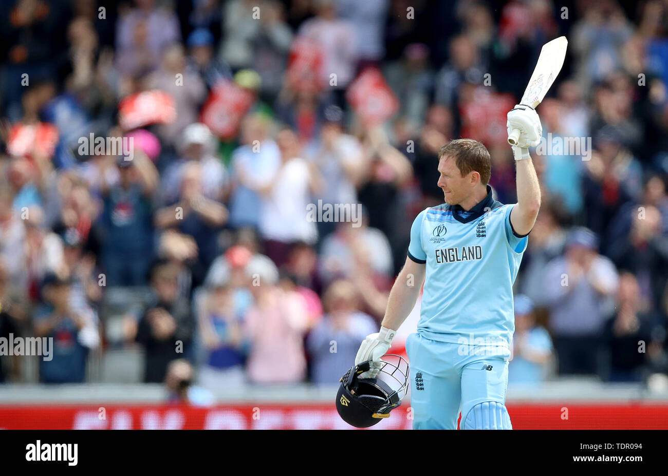 England's Eoin Morgan raises his bat after reaching a century during the ICC cricket World Cup group stage match at Old Trafford, Manchester. Stock Photo