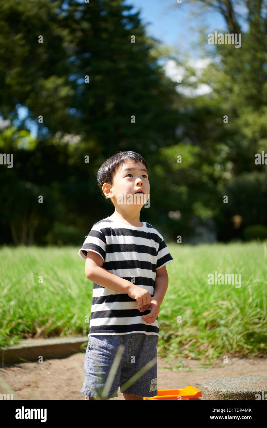 Japanese kid in a city park Stock Photo