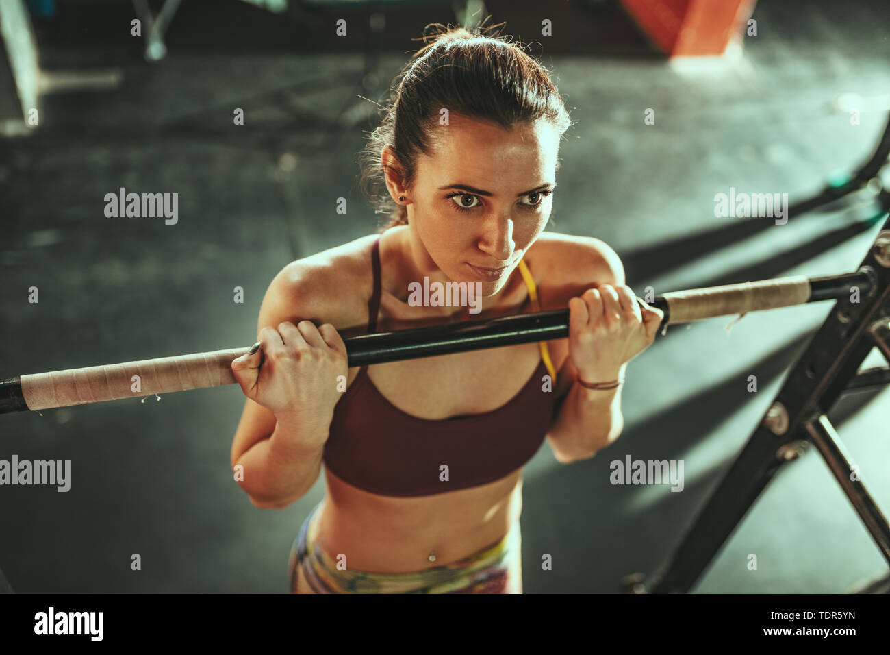 Beautiful young strong muscular woman is doing pull-up exercises at the ...