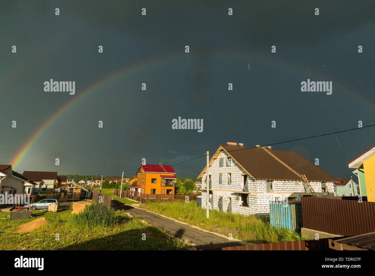 rainbow against the backdrop of a small house in the village Stock Photo