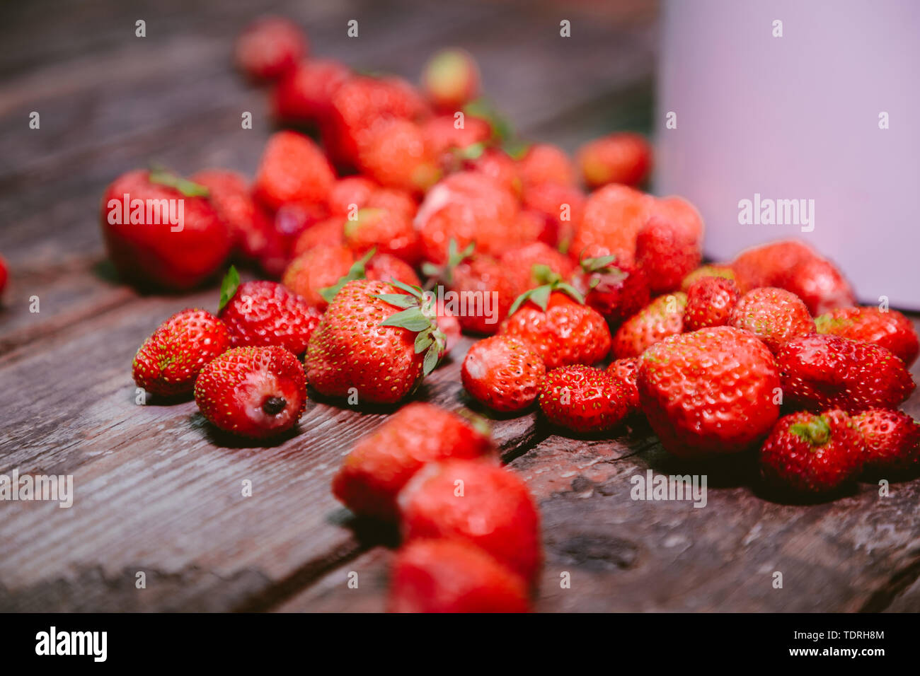 strewn strawberries on an old wooden table Stock Photo - Alamy