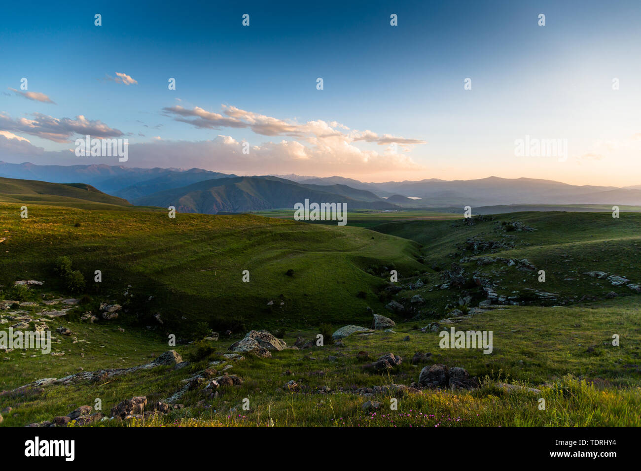 landscape of green hills and mountains and clouds Stock Photo