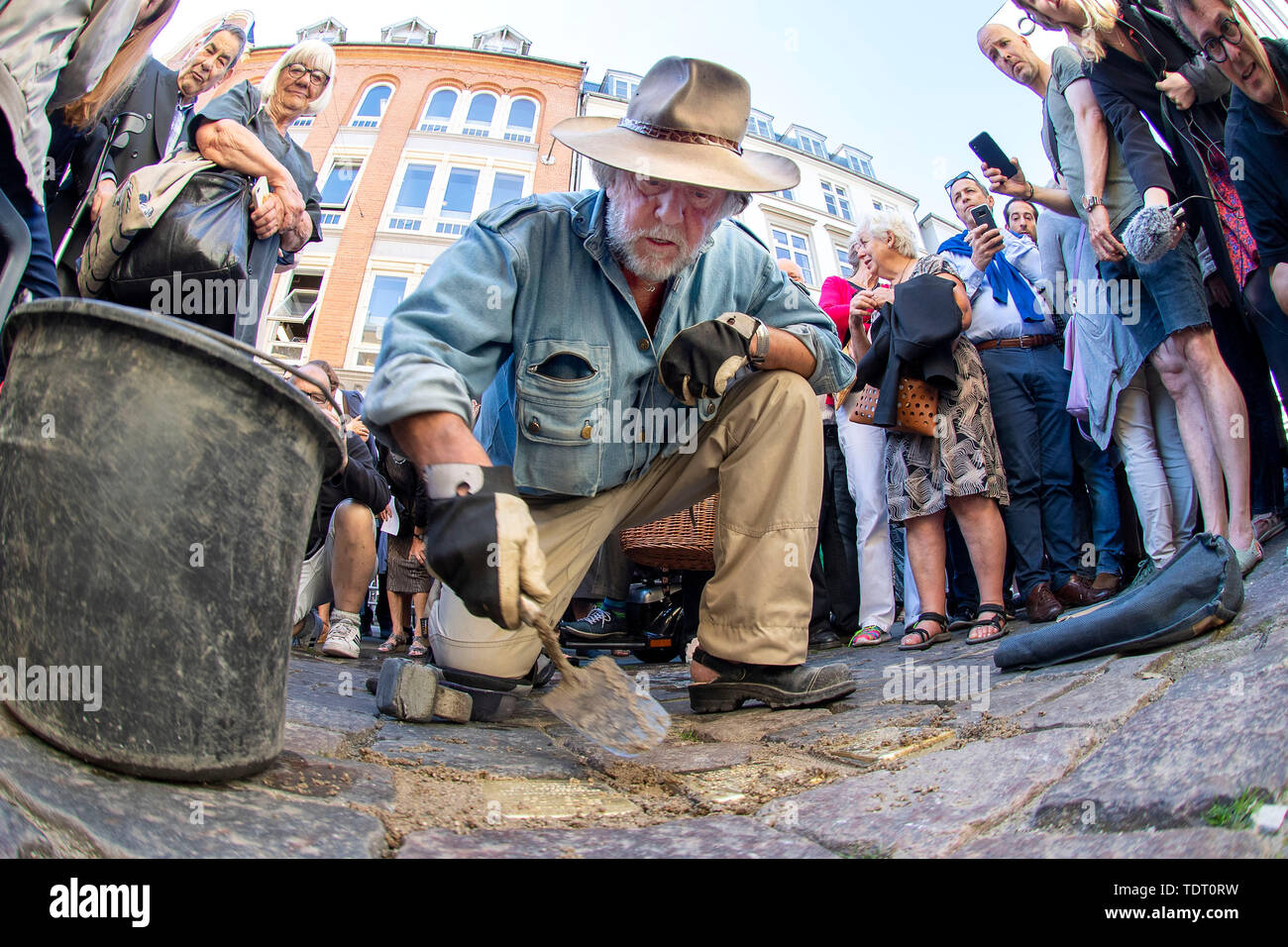 The German artist Gunter Demnig puts 3 Snublesten - Stolpersteine - in front of the Synagogue in Copenhagen, Monday, June 17, 2019. The stumbling block is the memorial stone laid in the pavement. The Danish initiative group behind the decommissioning has been adopted as the victims of the Holocaust. Some of the victims are Danish Jews, others are stateless. The Danish victims were deported after Nazi Germany in October 1943. Since 1992, Gunter Demnig has placed over 74, 000 snublests in 24 European countries . (Photo: THOMAS SJOERUP/Ritzau Scanpix) | Stock Photo