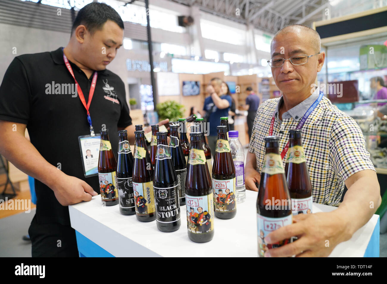 Harbin, China's Heilongjiang Province. 18th June, 2019. An exhibitor (L) learns about Russian beer during the 6th China-Russia Expo in Harbin, capital of northeast China's Heilongjiang Province, June 18, 2019. The expo, as an important platform for bilateral economic and trade cooperation, attracted more than 1,300 enterprises from China's 21 provincial-level regions and Russia's 18 oblasts. Credit: Wang Jianwei/Xinhua/Alamy Live News Stock Photo
