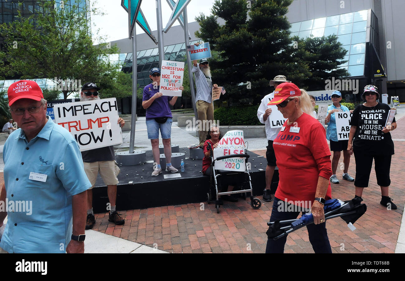 Orlando, Florida, USA. 18th June, 2019. Supporters of U.S. President Donald Trump walk past protesters near the site of a Make America Great Again rally at the Amway Center on June 18, 2019 in Orlando, Florida. The rally is billed as Trump's kick-off event for his campaign for re-election in 2020. Credit: Paul Hennessy/Alamy Live News Stock Photo