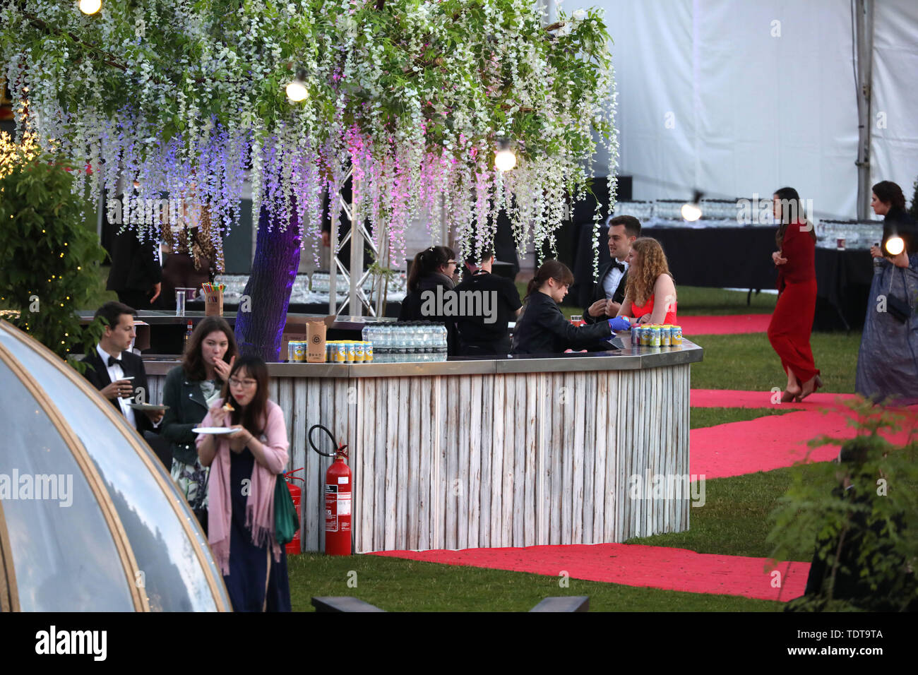 Cambridge, Cambridgeshire, UK. 18th June, 2019. University students being served at the bar, with plenty of water and light refreshments available, in the early hours of the morning after celebrating the end of their exams and attending the Trinity May Ball, Cambridge, Cambridgeshire, on June 18, 2019. Credit: Paul Marriott/Alamy Live News Stock Photo