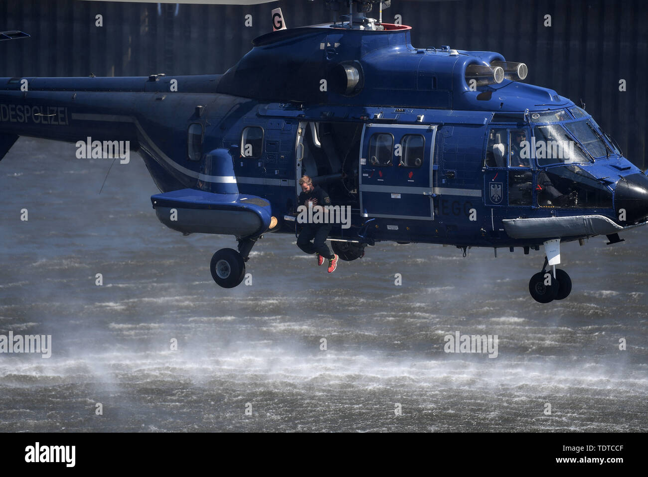 Bremen, Germany. 19th June, 2019. Police officers participating in a comparative exercise for evidence and arrest units jump from a helicopter into the harbour basin. The exercise takes place every two years and is also intended to train cooperation for international assignments. A total of 20 teams compete against each other, sometimes under extreme conditions. Credit: Carmen Jaspersen/dpa/Alamy Live News Stock Photo