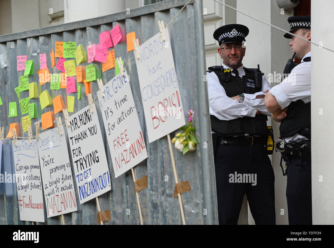 Police officers guard the Iranian Embassy in London, behind signs put up by supporters of Richard Radcliffe, the husband of detained Nazanin Zaghari Ratcliffe, who is on a hunger strike outside the embassy. Stock Photo