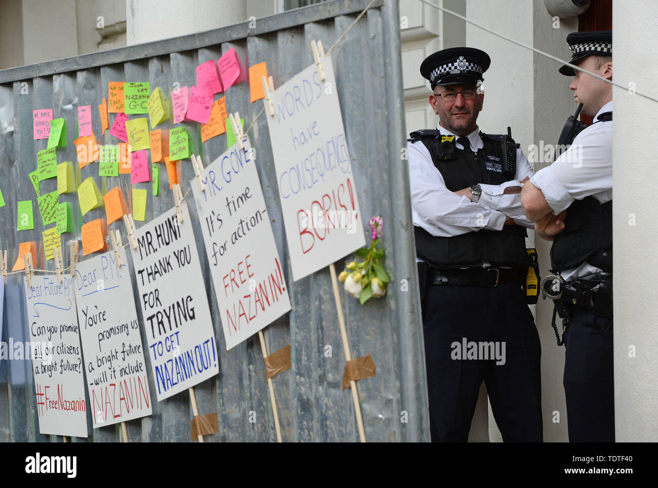 Police officers guard the Iranian Embassy in London, behind signs put up by supporters of Richard Ratcliffe, the husband of detained Nazanin Zaghari Ratcliffe, who is on a hunger strike outside the embassy. Stock Photo