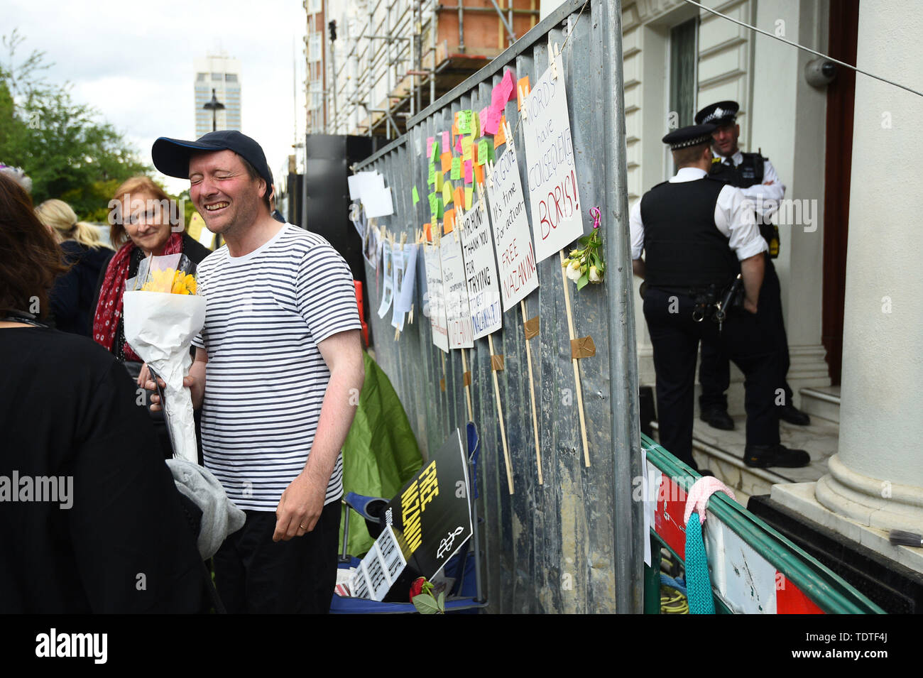 Richard Ratcliffe, the husband of detained Nazanin Zaghari Ratcliffe, receives flowers as police officers guard the Iranian Embassy in London, where he is on hunger strike. Stock Photo