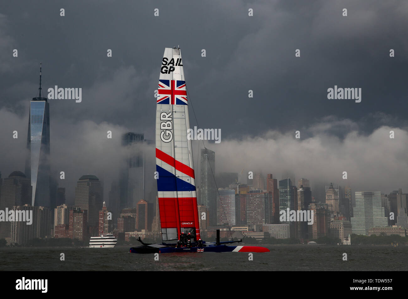 Great Britain SailGP Team skippered by Dylan Fletcher sails past the One World Trade Center as the practice race is cancelled due to bad weather at the Event 3 Season 1 SailGP event in New York City. Stock Photo