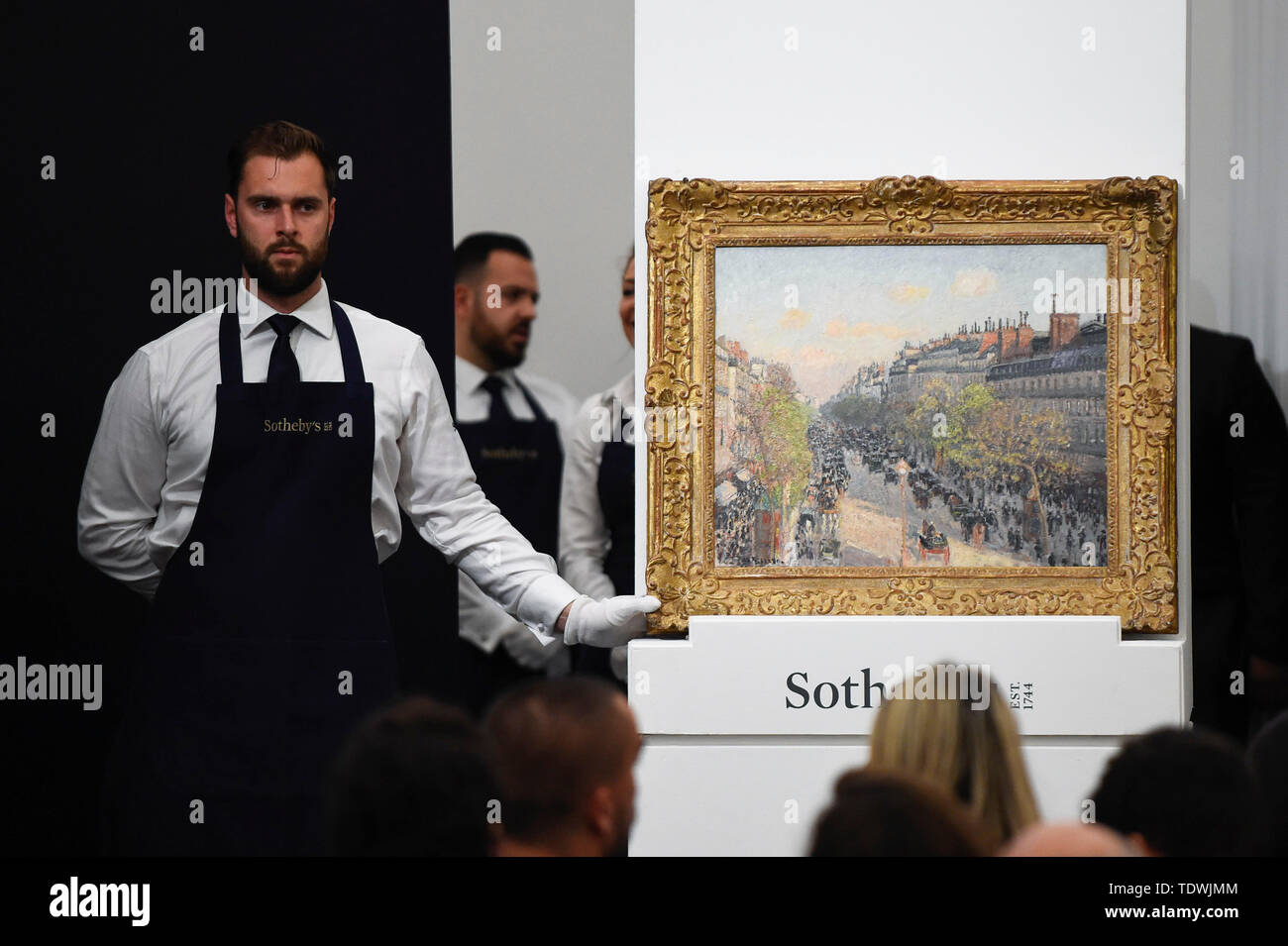 London, UK.  19 June 2019. A technician presents ''Le Boulevard Montmartre, Fin De Journée'' by Camille Pissarro, (Est. £3,500,000 - 5,000,000) which sold for a hammer price of £6,100,000 at Sotheby's Impressionist & Modern art evening sale in New Bond Street.  This is the first major evening sale to take place after Sotheby’s agreed to a takeover by media and telecoms billionaire Patrick Drahi in a deal valued at $3.7bn (£2.9bn).  The big five global auction houses (Sotheby's, Christie's, Bonhams, Phillips and China Guardian Auctions) will now be held privately.  Francois Pinault, another Fre Stock Photo