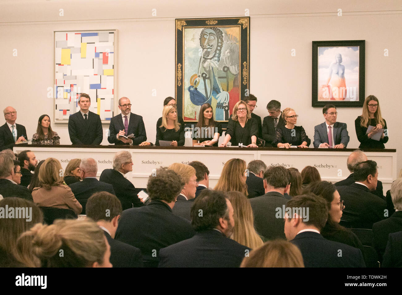 London UK. 19th June 2019. 'Sotheby's staff taking bids  for  L-R 'Relational Painting No 60 by Fritz Glamer, oil on canvas, Estimate £450,000 which sold at hammer for £620,000;'Homme a la pipe by Pablo Picasso, Estimate £5,500,000 m which sold at hammer for £6,500,000m; 'La magie noire, oil on canvas  by René Magritte, Estimate £2,500,000 which sold at hammer for £3,500,000 at the Impressionist & Modern Art Evening Auction  at Sotheby’s London London Credit: amer ghazzal/Alamy Live News Stock Photo