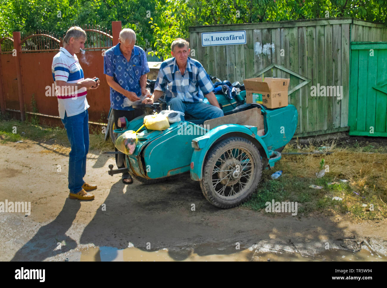 village people standing at a motorcycles with sidecar, Moldova, Puchacheni Stock Photo