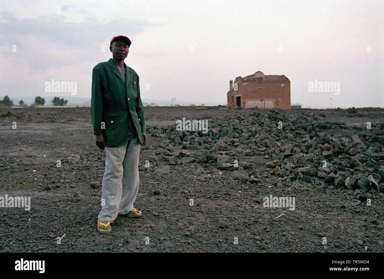 man standing in front of a new house, Republic of the Congo, Goma Stock Photo