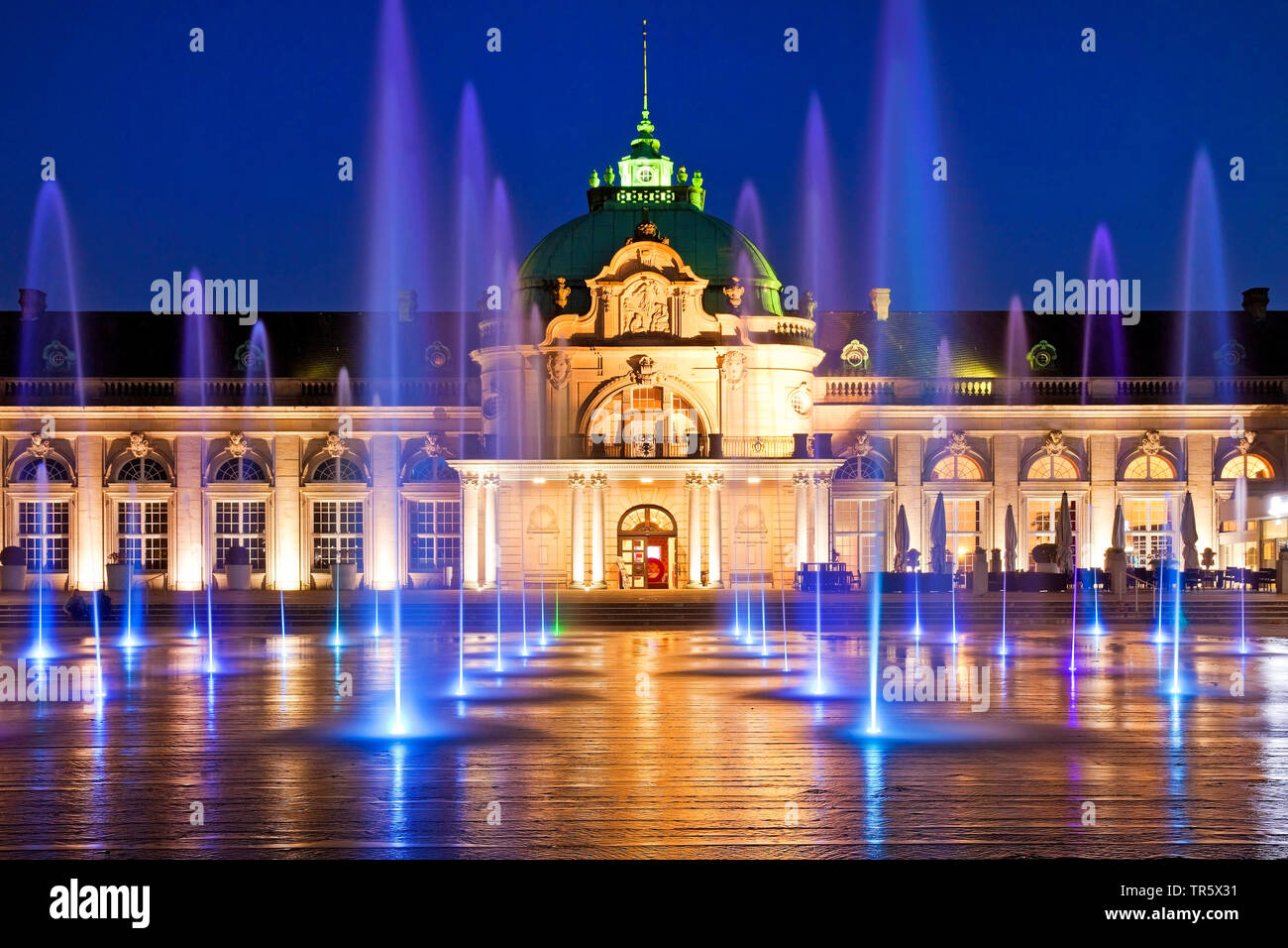 illuminated Kaiserpalais with mit water columns in the spa park at blue hour, Germany, North Rhine-Westphalia, East Westphalia, Bad Oeynhausen Stock Photo