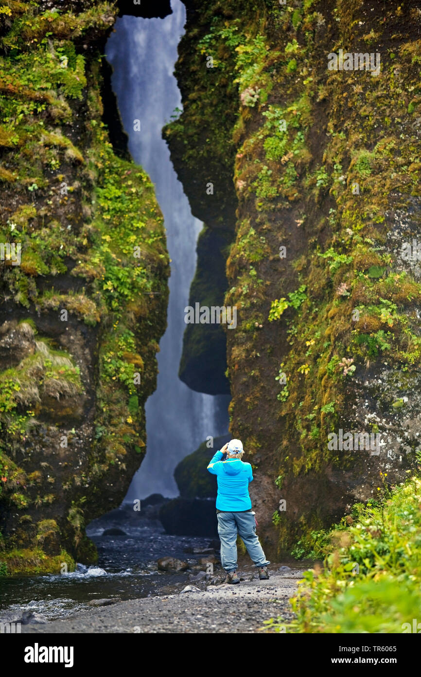 tourist taking picture of little waterfall Glufrafoss in Seljaland, Iceland, South Iceland, Seljaland Stock Photo