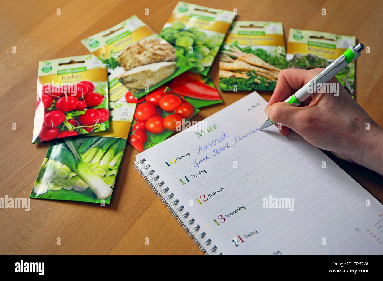 woman writing down dates of seeding, Germany Stock Photo