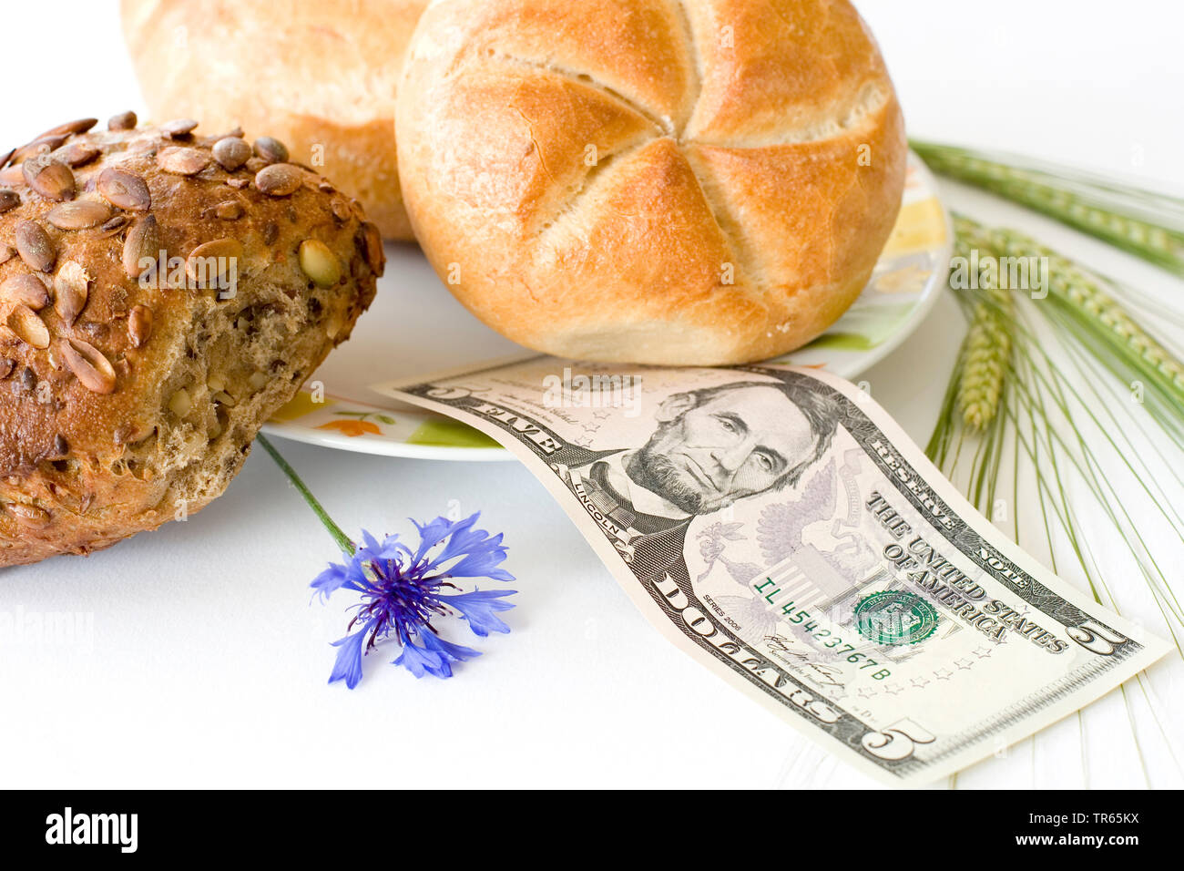bread roll s with 5 dollar bill, cornflower and barley, USA Stock Photo