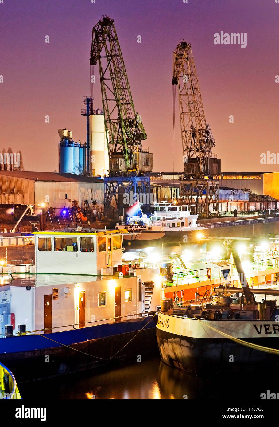 freight ships and cranes in inland port Duisburg at night, Germany, North Rhine-Westphalia, Ruhr Area, Duisburg Stock Photo