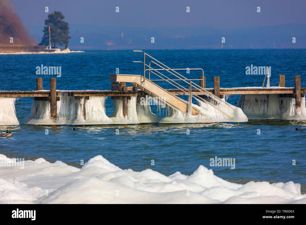 weirdly shaped icing on a bathing jetty after winter storm, Germany, Bavaria, Lake Chiemsee Stock Photo