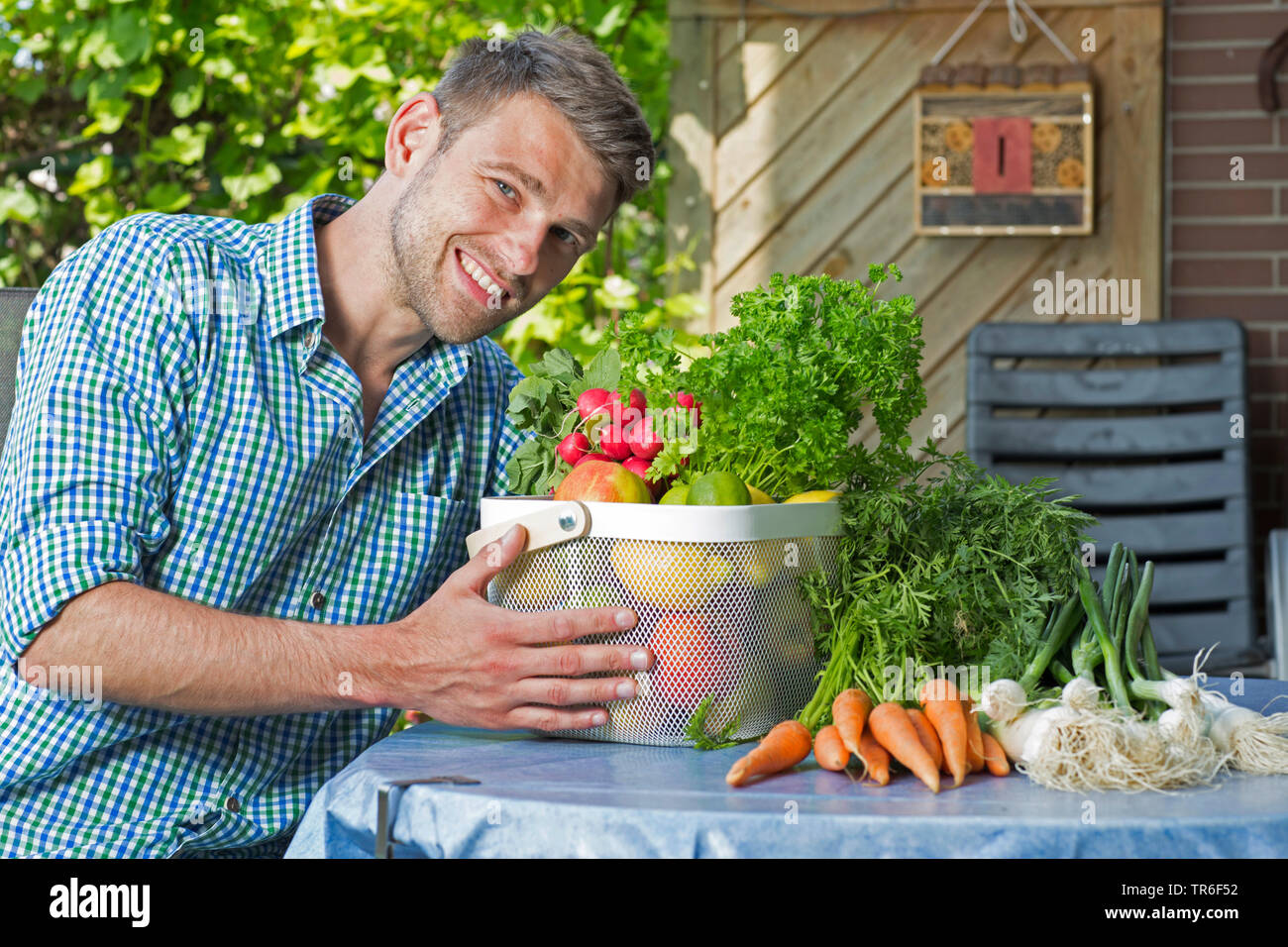 young man with fruit and vegetable basket, Germany Stock Photo
