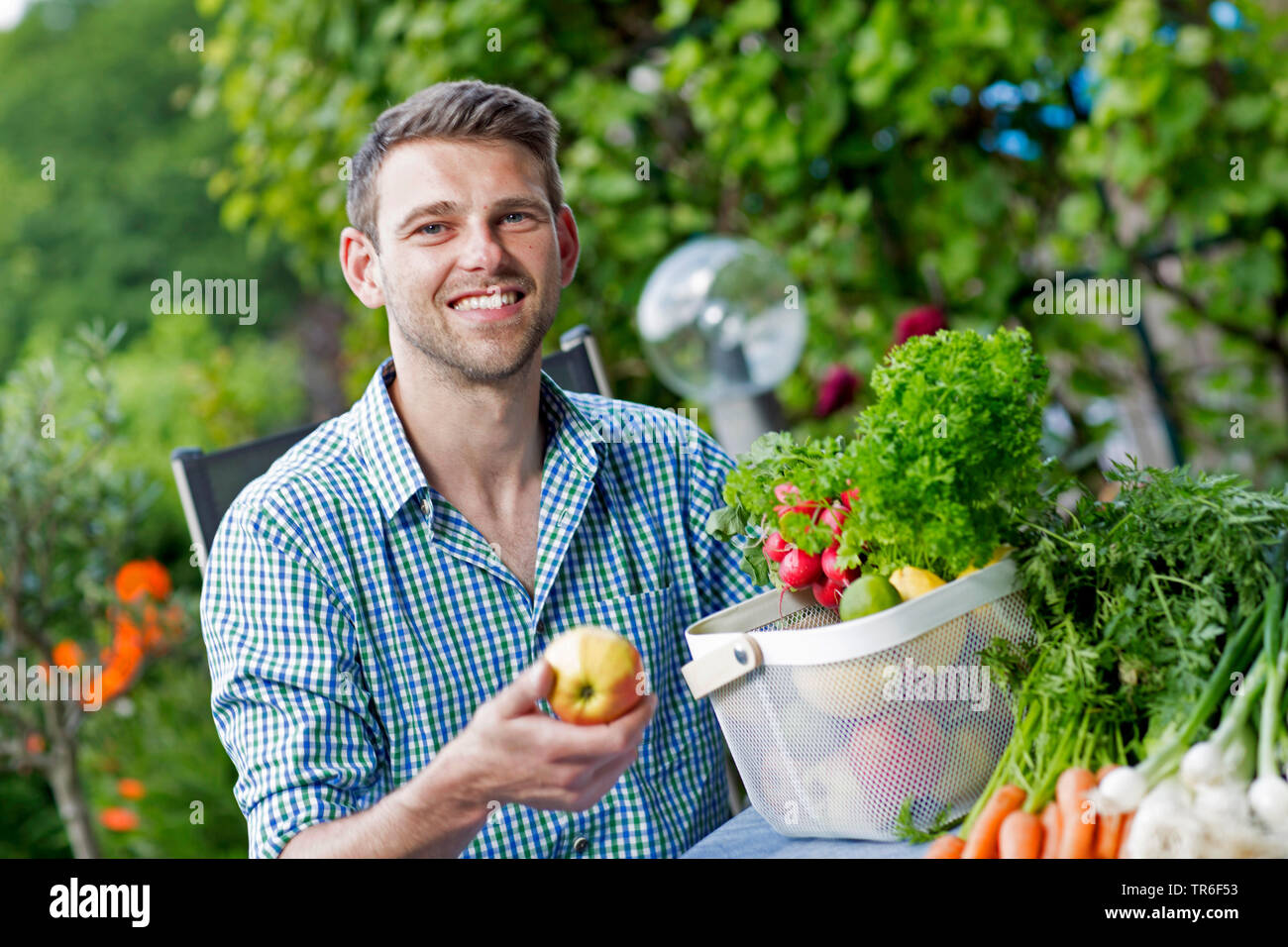 young man with fruit and vegetable basket, Germany Stock Photo