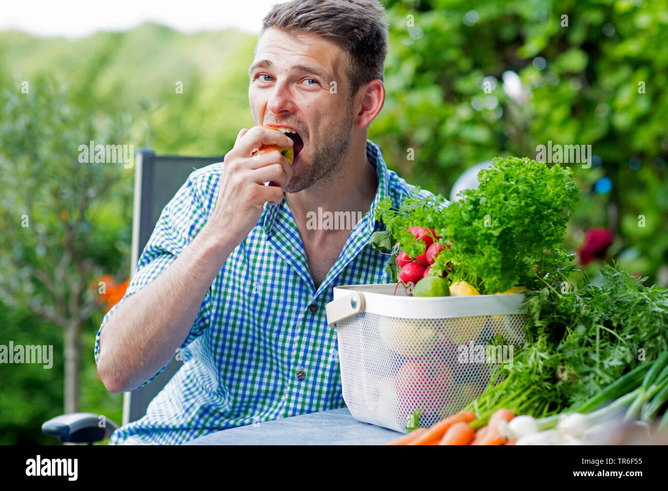 young man biting into an apple, Germany Stock Photo