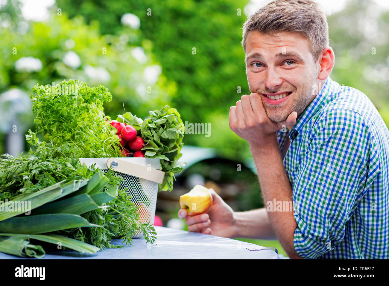 young man has bitten into a sour apple, Germany Stock Photo