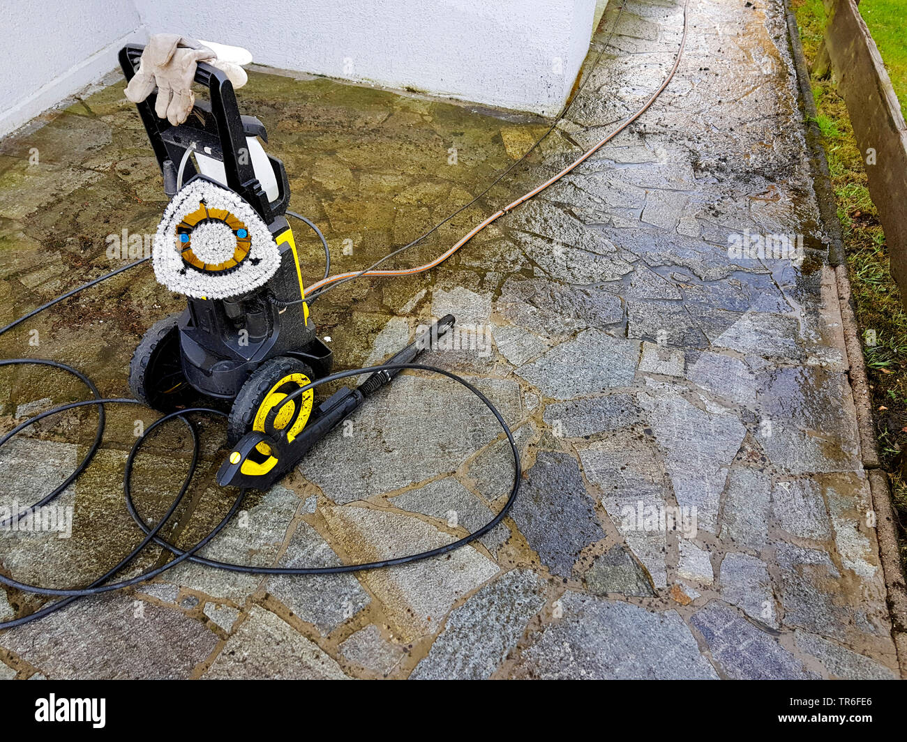 Steinplattenweg wird mit Hochdruckreiniger gesaeubert, Deutschland | natural stone slabs is cleaned with a pressure washer, Germany | BLWS482891.jpg [ Stock Photo