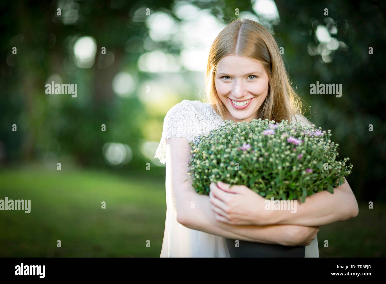 young blond woman with an aster in the arm , Germany Stock Photo