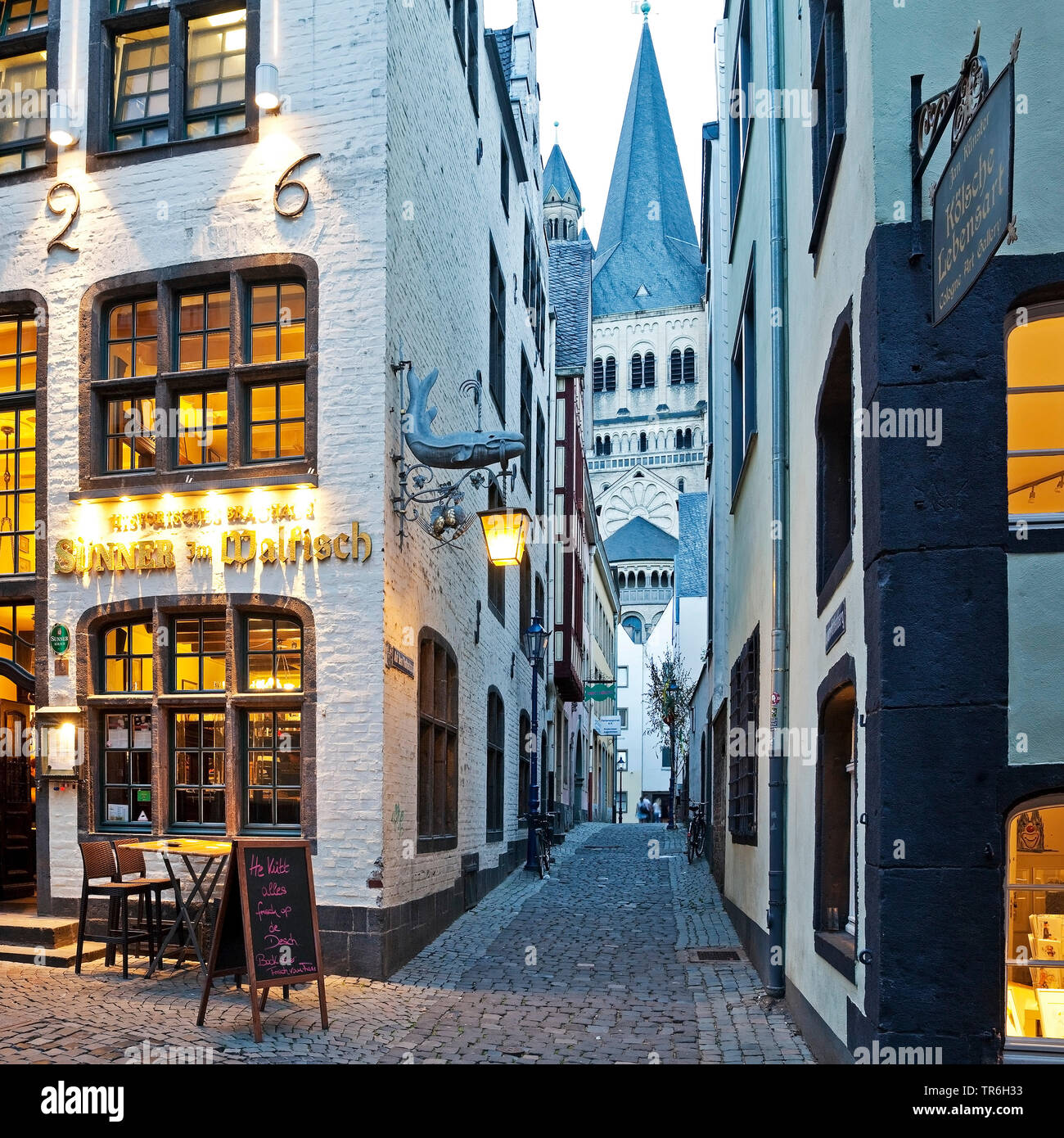 Salzgasse with restaurant, view through narrow lane to Great St. Martin Church in the evening, Germany, North Rhine-Westphalia, Cologne Stock Photo