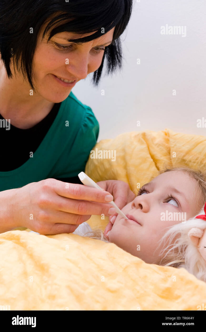 sick girl n bed, mother with clinical thermometer Stock Photo