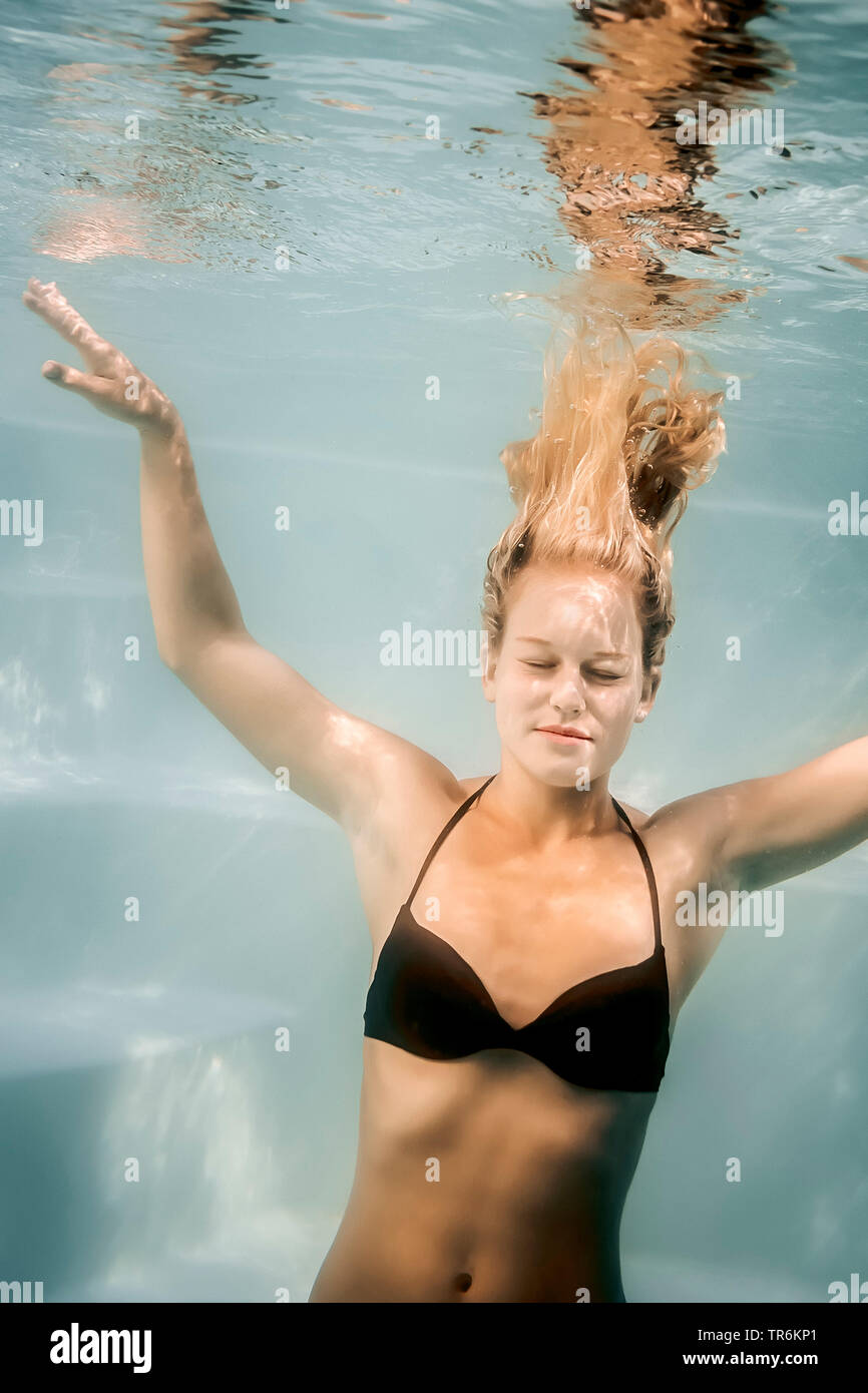 young blond woman diving in a swimming pool, Germany Stock Photo