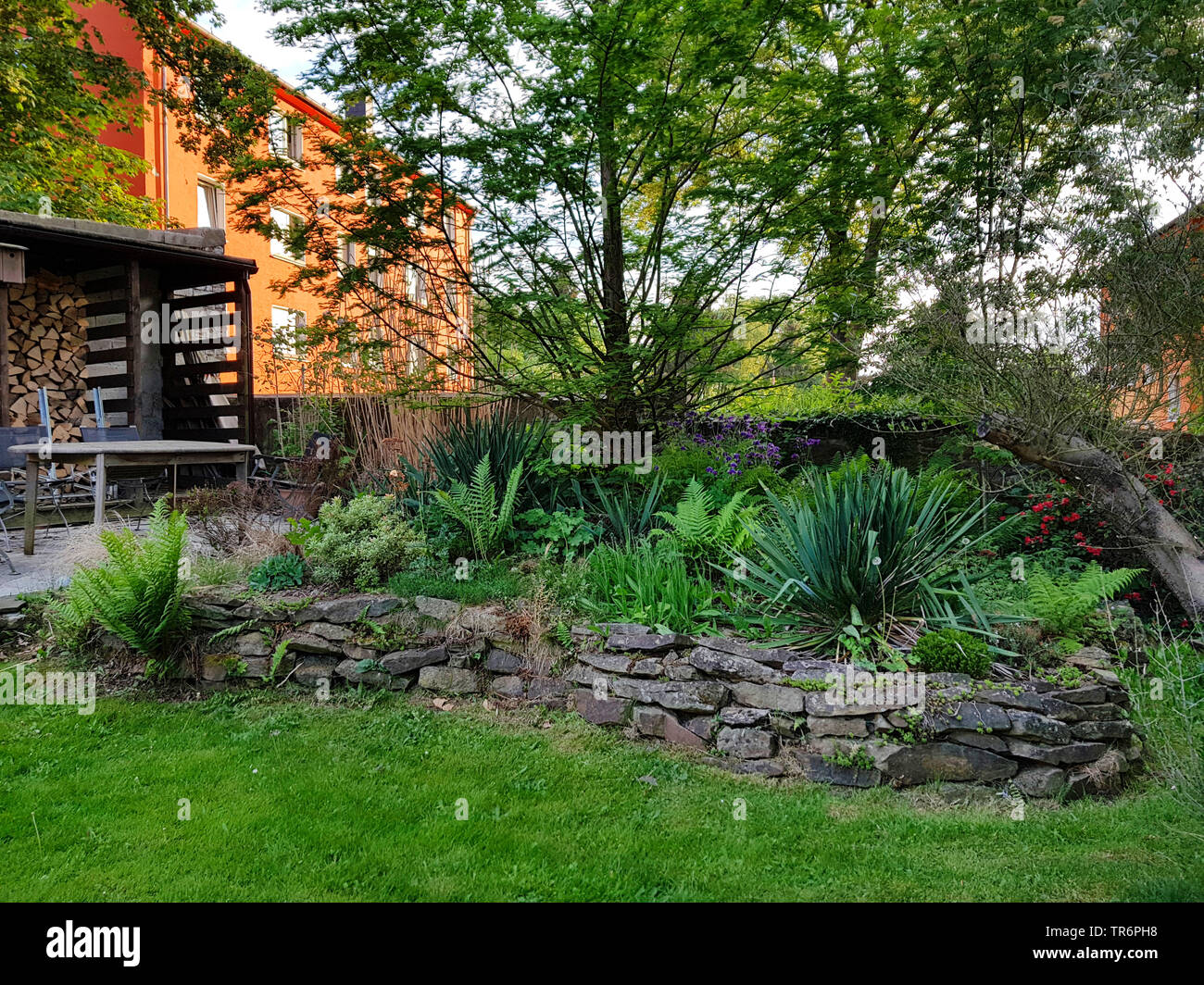raised bed with natural stone wall in summer, Germany Stock Photo