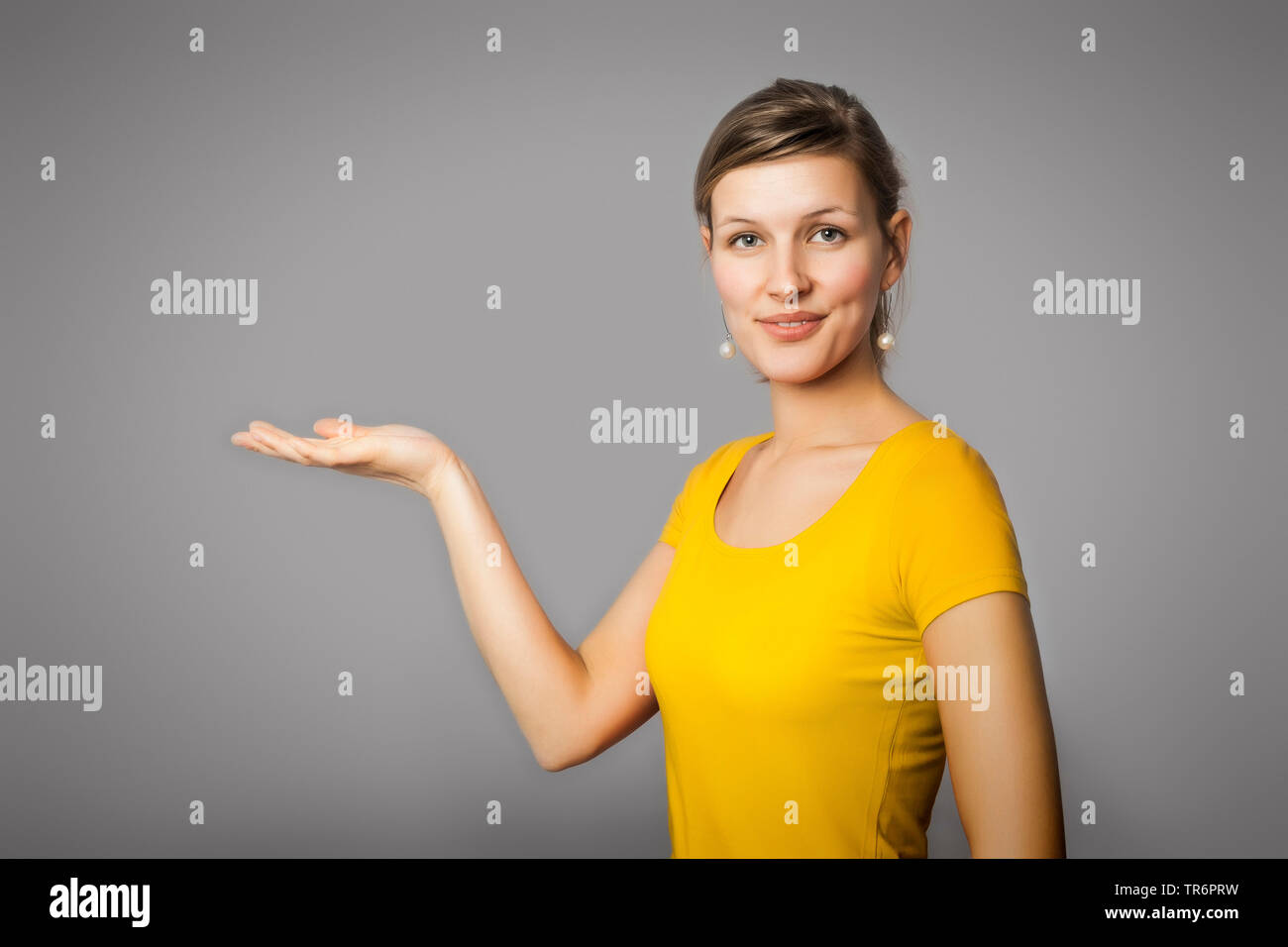 young woman, who presenting someting on her palm, Germany Stock Photo