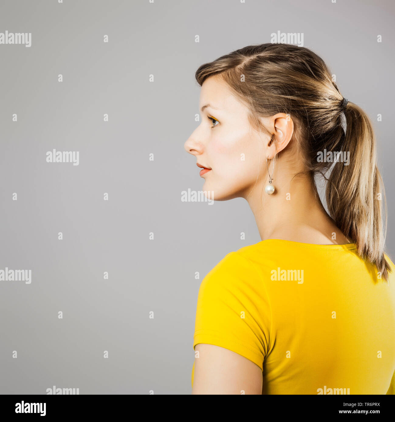 beautiful woman in yellow T-shirt, side view, Germany Stock Photo