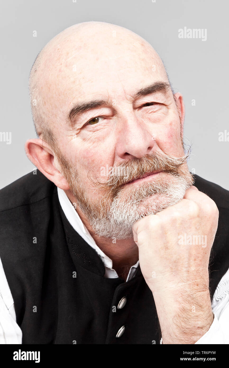 Portrait of old, baldheaded man with grey beard looking at camera. Stock Photo