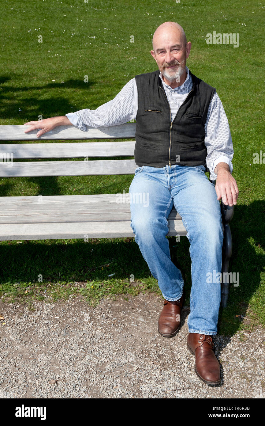 old man with a grey beard on a park bench, Germany Stock Photo