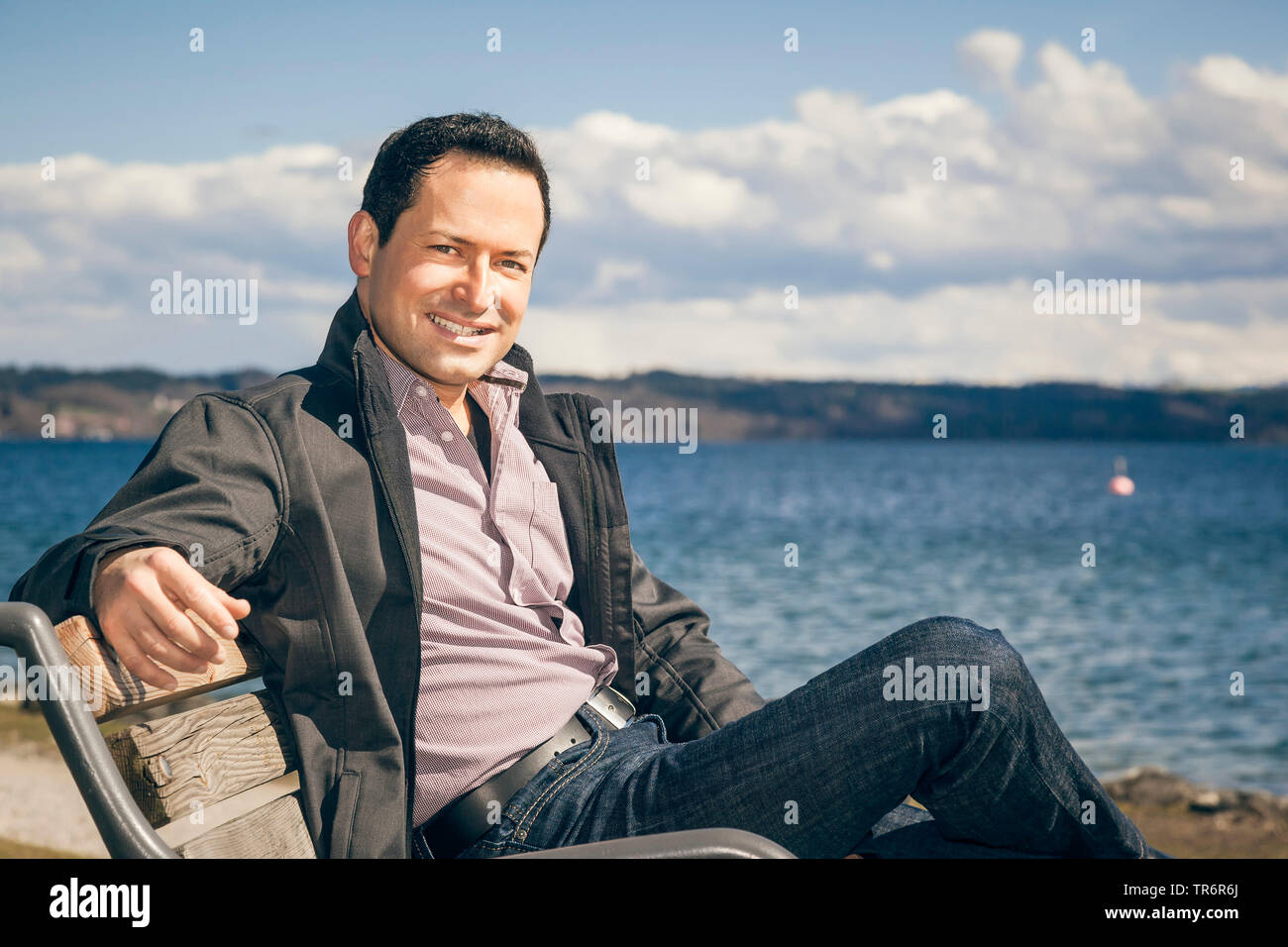 man sitting on a bench at a lake, Germany Stock Photo
