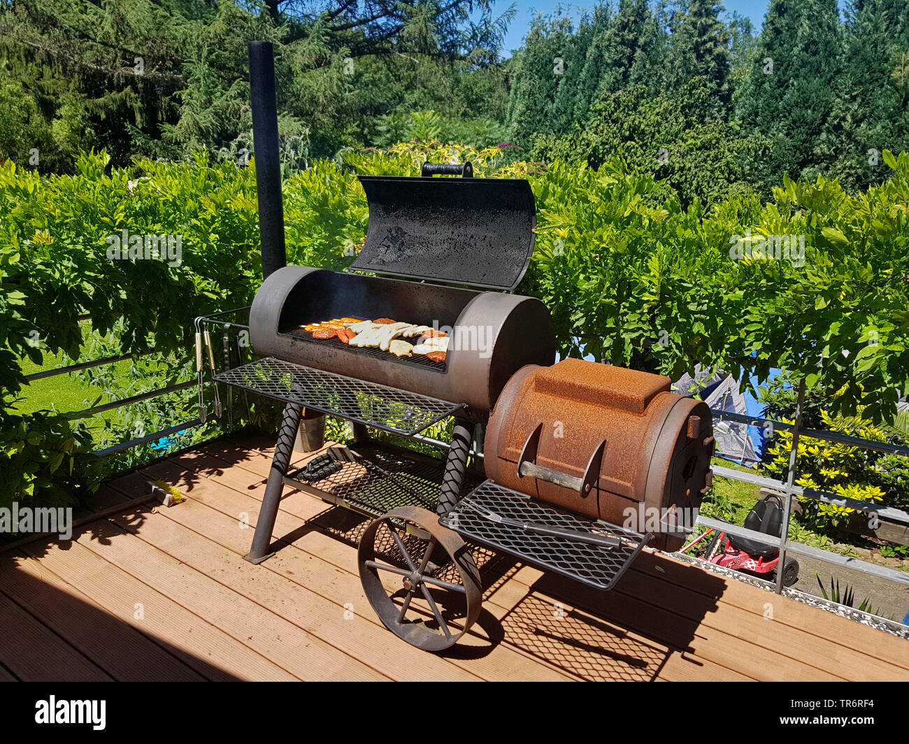 grill meat in a Barbecue-Smoker on a terrace, Germany Stock Photo