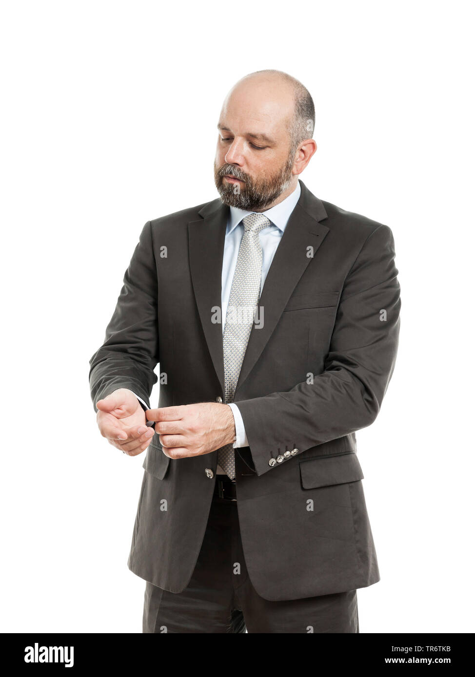 Middle-aged businessmann in full suit adjusting his sleeve, Germany Stock Photo