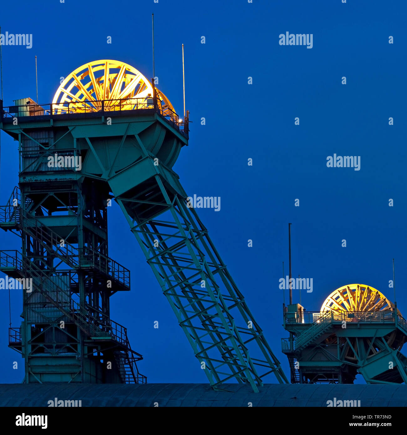 illuminated sheave on top of winding tower of former coal mine Westfalen in the evening, Germany, North Rhine-Westphalia, Muensterland, Ahlen Stock Photo