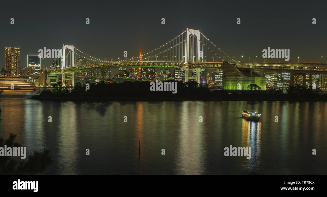 Iconic view from Odaiba on Reinbow Bridge and Tokyo Tower in illuminated City centre of japans capital at evening, October 2018 Stock Photo