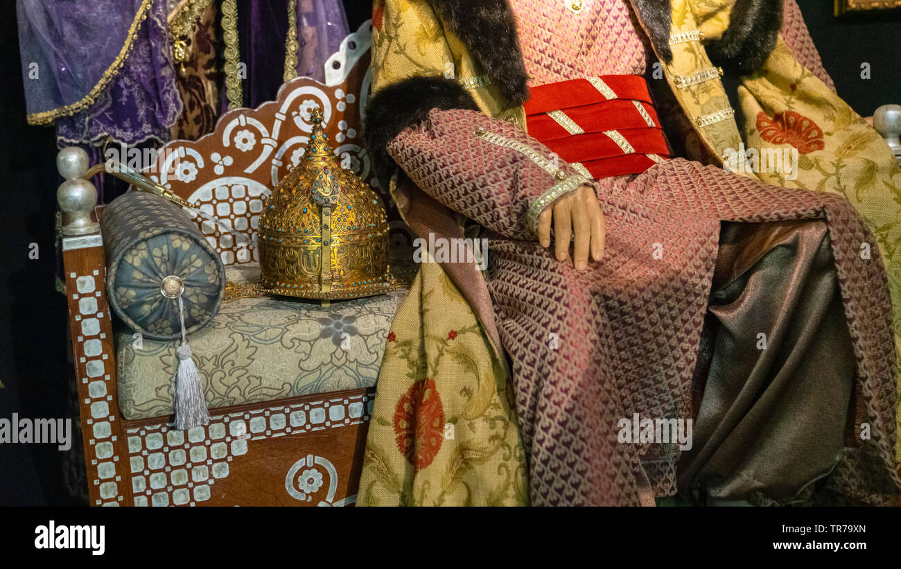 Ottoman king sitting on throne, and his helmet also on throne, concept of power. Stock Photo