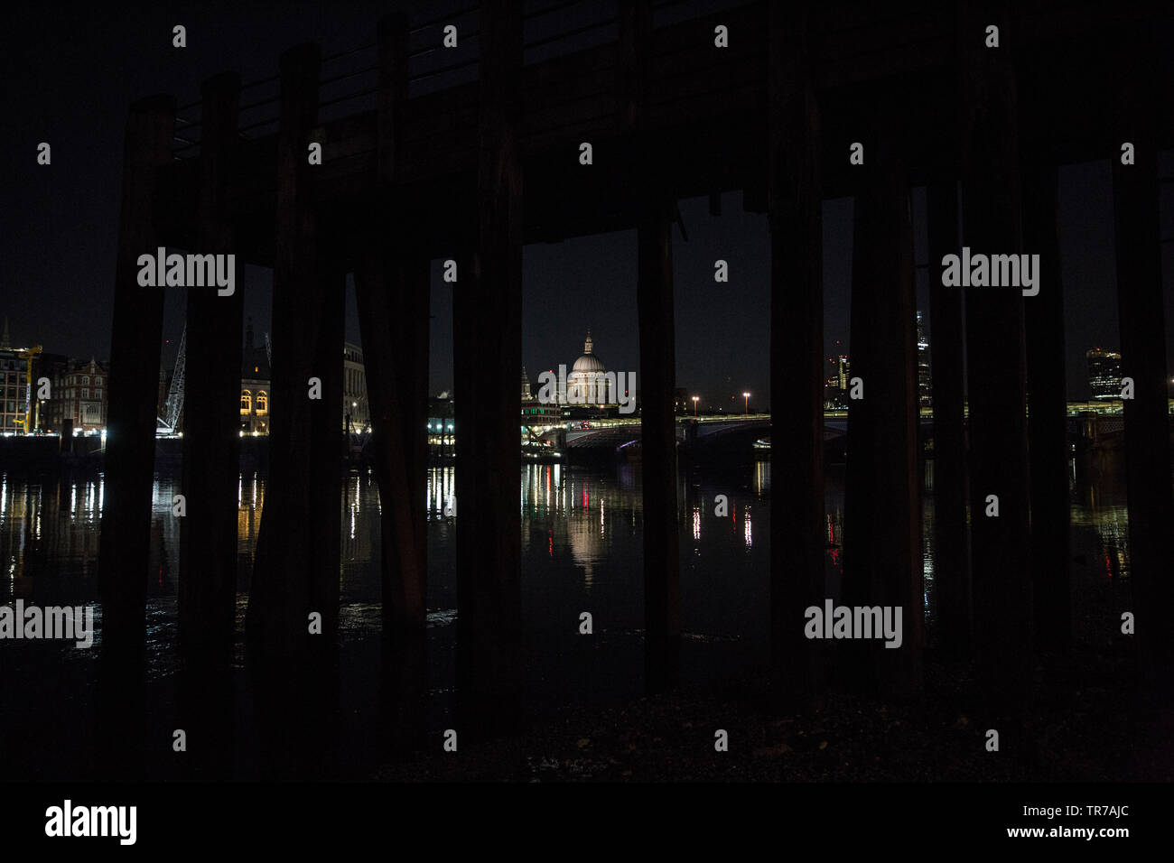 St Paul's Cathedral at dawn, photographed from the banks of the River Thames under an old victorian wooden pier, London, England, UK Stock Photo